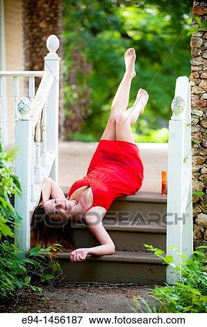 A 36 year old brunette woman in a red summer dress lying on her back on porch steps looking directly at camera View Large Photo Image Stock Photo - A 36 year old brunette woman in a red summer dress lying on her back on porch steps looking directly at camera. Fotosearch