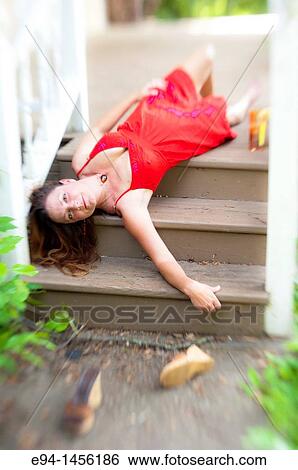 A 36 year old brunette woman in a red summer dress lying on her back on porch steps looking directly at camera View Large Photo Image Stock Photograph - A 36 year old brunette woman in a red summer dress lying on her back on porch steps looking directly at camera. Fotosearch