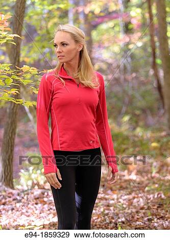 A 38 year old blond woman wearing work-out clothing walking through a forest setting in the fall View Large Photo Image Stock Photo - A 38 year old blond woman wearing work-out clothing walking through a forest setting in the fall. Fotosearch