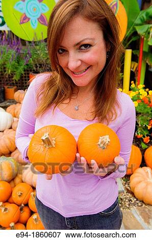 A 38 year old redheaded woman in a garden shop 2 small pumpkins in front of her chest View Large Photo Image Stock Photo - A 38 year old redheaded woman in a garden shop 2 small pumpkins in front of her chest. Fotosearch