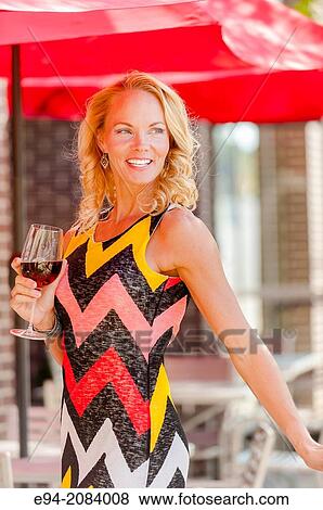 A 39 year old blond woman wearing a short dress at an outdoor cafe with a glass of red wine. View Large Photo Image Stock Photo - A 39 year old blond woman wearing a short dress at an outdoor cafe with a glass of red wine.. Fotosearch