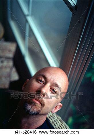 Stock Photograph - A 40 year old man reclines at his parents? house in Pennsylvania, USA.. Fotosearch