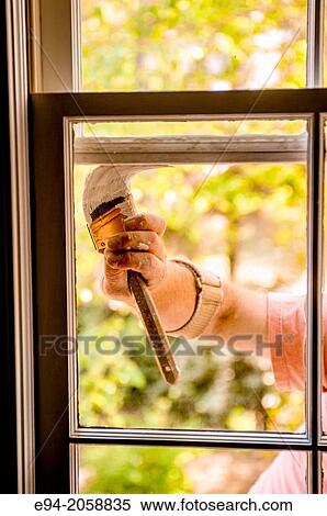 A 41 year old man painting the window trim of a house facing inside. View Large Photo Image Stock Photography - A 41 year old man painting the window trim of a house facing inside.. Fotosearch