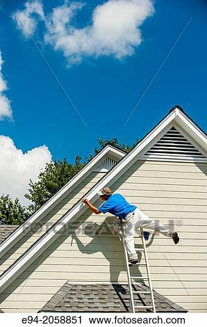 A 45 year old man on a ladder balancing on one leg clowning around while painting a house. View Large Photo Image Stock Image - A 45 year old man on a ladder balancing on one leg clowning around while painting a house.. Fotosearch