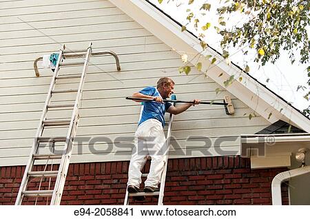 A 45 year old man on a ladder cleaning the wood siding of a house with a brush. View Large Photo Image Stock Image - A 45 year old man on a ladder cleaning the wood siding of a house with a brush.. Fotosearch