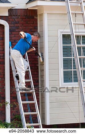 A 45 year old man on a ladder cleaning the wood siding of a house with a brush. View Large Photo Image Stock Image - A 45 year old man on a ladder cleaning the wood siding of a house with a brush.. Fotosearch