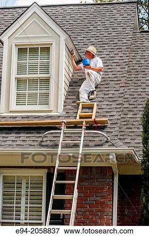 A 45 year old man on a roof painting the white trim of a house. View Large Photo Image Stock Photo - A 45 year old man on a roof painting the white trim of a house.. Fotosearch