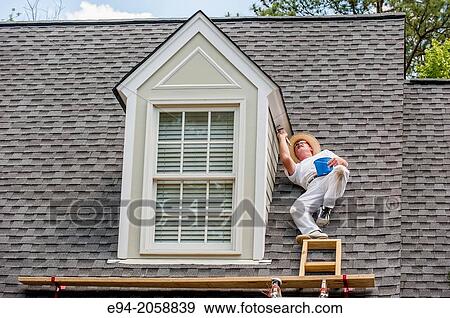 A 45 year old man on a roof painting the white trim of a house. View Large Photo Image Stock Photo - A 45 year old man on a roof painting the white trim of a house.. Fotosearch