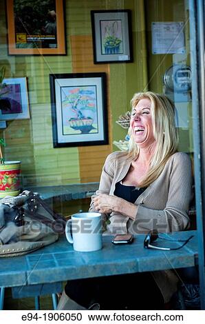 A 48 year old blond woman in casual clothing relaxing in a coffee shop seen through the window View Large Photo Image Stock Image - A 48 year old blond woman in casual clothing relaxing in a coffee shop seen through the window. Fotosearch