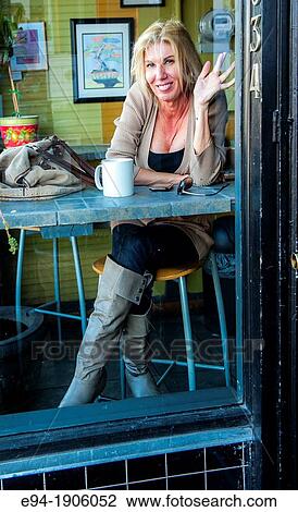 A 48 year old blond woman in casual clothing relaxing in a coffee shop seen through the window View Large Photo Image Stock Image - A 48 year old blond woman in casual clothing relaxing in a coffee shop seen through the window. Fotosearch