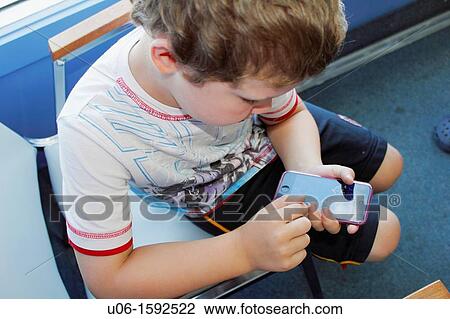 a 5 year old boy using an IPod or IPhone or cell phone View Large Photo Image Stock Image - a 5 year old boy using an IPod or IPhone or cell phone. Fotosearch