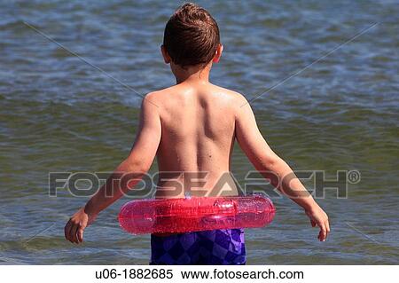 a 5 year old boy wearing a red life ring about to go swimming in the ocean View Large Photo Image Stock Photography - a 5 year old boy wearing a red life ring about to go swimming in the ocean. Fotosearch