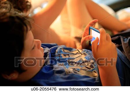 A 9 year old boy playing games on an apple ipod touch electronic device View Large Photo Image Stock Photograph - A 9 year old boy playing games on an apple ipod touch electronic device. Fotosearch