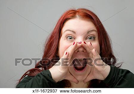 A auburn haired caucasian woman yelling shouting screaming with her hands cupped around her mouth View Large Photo Image Stock Photo - A auburn haired caucasian woman yelling shouting screaming with her hands cupped around her mouth. Fotosearch