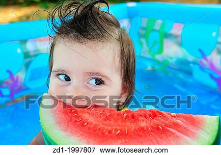 A baby girl eats a cold watermelon in a baby pool in a very hot day. View Large Photo Image Stock Photo - A baby girl eats a cold watermelon in a baby pool in a very hot day.. Fotosearch