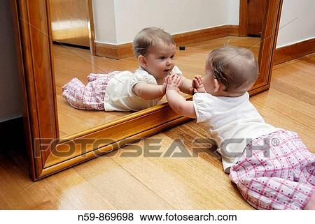 A baby girl, eight months old, in front of a large mirror View Large Photo Image Stock Photo - A baby girl, eight months old, in front of a large mirror. Fotosearch