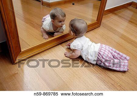 A baby girl, eight months old, in front of a large mirror View Large Photo Image Stock Photography - A baby girl, eight months old, in front of a large mirror. Fotosearch