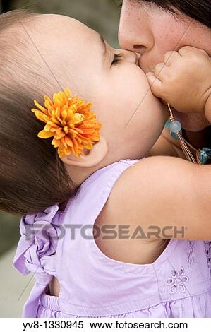 Stock Photography - A baby girl kissing her mother. Fotosearch