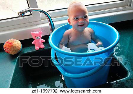 A baby in a blue bucket cools off in the summer heat. View Large Photo Image Stock Image - A baby in a blue bucket cools off in the summer heat.. Fotosearch