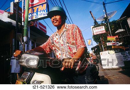 A Balinese man on a motorbike in downtown Kuta Beach. Bali. View Large Photo Image Stock Photograph - A Balinese man on a motorbike in downtown Kuta Beach. Bali.. Fotosearch