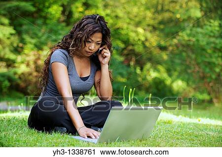 A beautiful African American woman using laptop while holding a smartphone View Large Photo Image Stock Image - A beautiful African American woman using laptop while holding a smartphone. Fotosearch