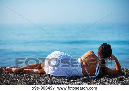 A beautiful woman relaxing on a beach View Large Photo Image Stock Photo - A beautiful woman relaxing on a beach. Fotosearch