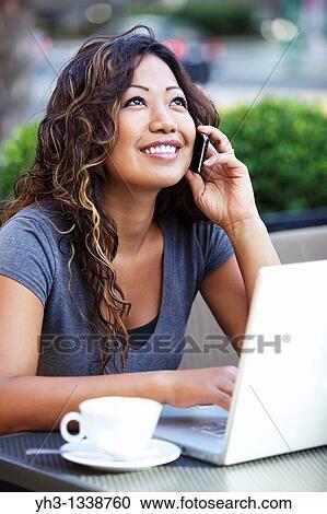 A beautiful woman using laptop while holding a smartphone View Large Photo Image Stock Image - A beautiful woman using laptop while holding a smartphone. Fotosearch