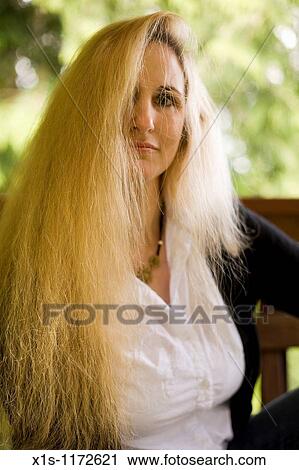 A Beautiful Woman With Very Long Blonde Hair Posing Outside Stock