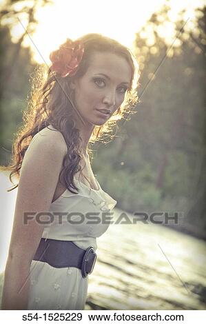 Stock Photo - A beautiful young caucasian woman outdoors in Spokane, Washington, USA, with the Spokane River in the background.. Fotosearch