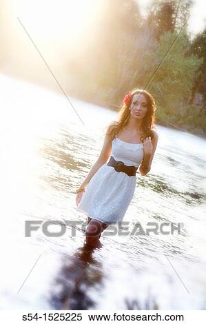 Stock Photography - A beautiful young caucasian woman outdoors in Spokane, Washington, USA, standing in the Spokane River.. Fotosearch