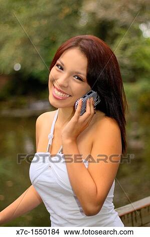 Picture - A beautiful young lady enjoying her smartphone. Fotosearch