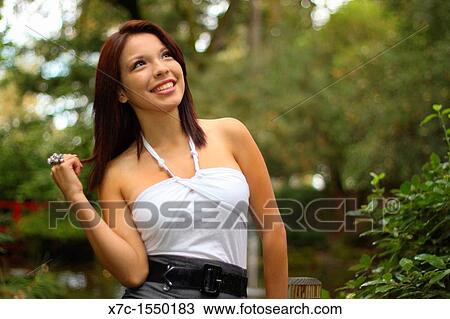 Stock Image - A beautiful young lady enjoying her smartphone. Fotosearch