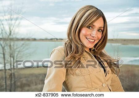 A beautiful young woman standing in front of a frozen lake in Colorado (USA) smiling View Large Photo Image Stock Photography - A beautiful young woman standing in front of a frozen lake in Colorado (USA) smiling. Fotosearch