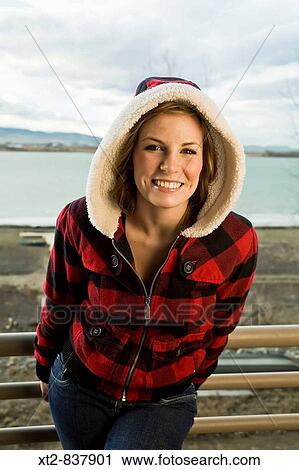 A beautiful young woman standing on a deck in front of a frozen lake in Colorado (USA) smiling View Large Photo Image Stock Image - A beautiful young woman standing on a deck in front of a frozen lake in Colorado (USA) smiling. Fotosearch