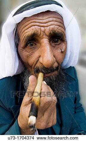 A Bedouin man smoking a traditional cigar in the old city of Jerusalem View Large Photo Image Picture - A Bedouin man smoking a traditional cigar in the old city of Jerusalem. Fotosearch