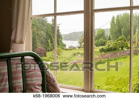 Stock Photograph - A bedroom with a view on Saturna Island, Gulf Islands, BC, Canada. Fotosearch