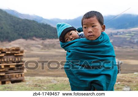 A Bhutanese boy carrying his little brother on his back, Phobjikha Valley, Gangtey, Bhutan, Asia. View Large Photo Image Stock Photo - A Bhutanese boy carrying his little brother on his back, Phobjikha Valley, Gangtey, Bhutan, Asia.. Fotosearch