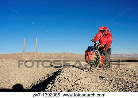 Stock Photography - A biker in the Andes, Salta district, to the west of San Antonio de los Cobres, Argentina, on the way to the border with Chile. Fotosearch