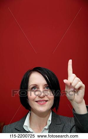 A black haired young woman pointing her finger up. View Large Photo Image Stock Photography - A black haired young woman pointing her finger up.. Fotosearch