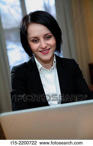 A black haired young woman working on a computer. View Large Photo Image Stock Image - A black haired young woman working on a computer.. Fotosearch