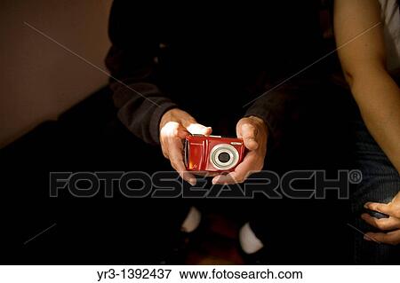 Stock Photo - A blind male student touches a camera. Fotosearch