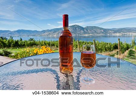 A bottle and a glass of ros? wine at a vineyard in the Okanagan Valley, British Columbia, Canada View Large Photo Image Picture - A bottle and a glass of ros? wine at a vineyard in the Okanagan Valley, British Columbia, Canada. Fotosearch