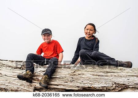 a boy, 10 and a girl, 11, sit on a log View Large Photo Image Stock Photography - a boy, 10 and a girl, 11, sit on a log. Fotosearch