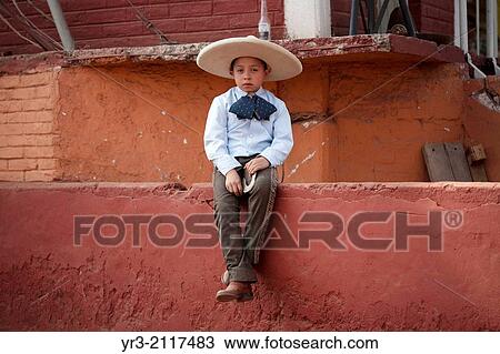 A boy dressed as a charro carries her horse during an Escaramuza fair in the Lienzo Charros el Penon, Mexico City, Sunday, January 19, 2013. View Large Photo Image Stock Image - A boy dressed as a charro carries her horse during an Escaramuza fair in the Lienzo Charros el Penon, Mexico City, Sunday, January 19, 2013.. Fotosearch