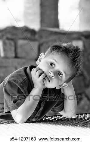 A boy looks thoughtful, sitting at a bench View Large Photo Image Stock Image - A boy looks thoughtful, sitting at a bench. Fotosearch