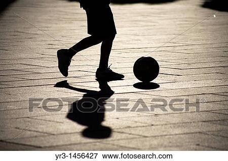 Stock Photo - A boy plays soccer in the main square of Mrida, Badajoz province, Extremadura region.. Fotosearch
