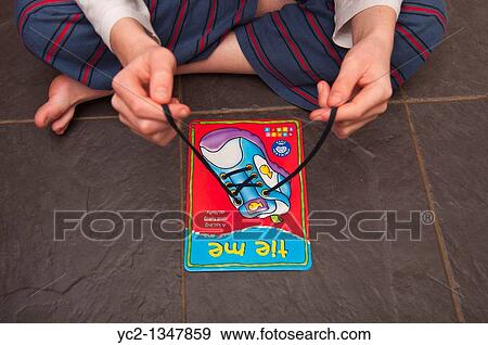 A boy practises tying shoelaces on a learning card by orchard toys in the Uk View Large Photo Image Stock Photo - A boy practises tying shoelaces on a learning card by orchard toys in the Uk. Fotosearch