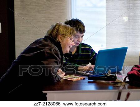 A boy shows his grandmother a computer project. View Large Photo Image Stock Photograph - A boy shows his grandmother a computer project.. Fotosearch