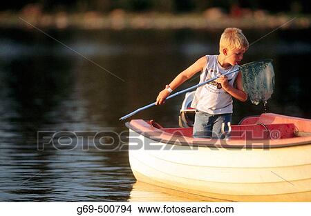 A boy, siw years old, catches small fish from a boat with a landing net. Batvik. Vasterbotten. Sweden. View Large Photo Image Picture - A boy, siw years old, catches small fish from a boat with a landing net. Batvik. Vasterbotten. Sweden.. Fotosearch