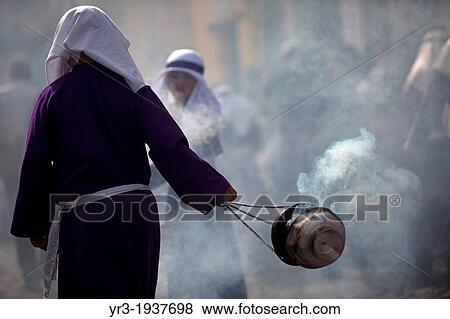 Stock Photo - A boy spread incense during La Merced's children Easter Holy Week procession in Antigua Guatemala, Guatemala, March 27, 2013.. Fotosearch